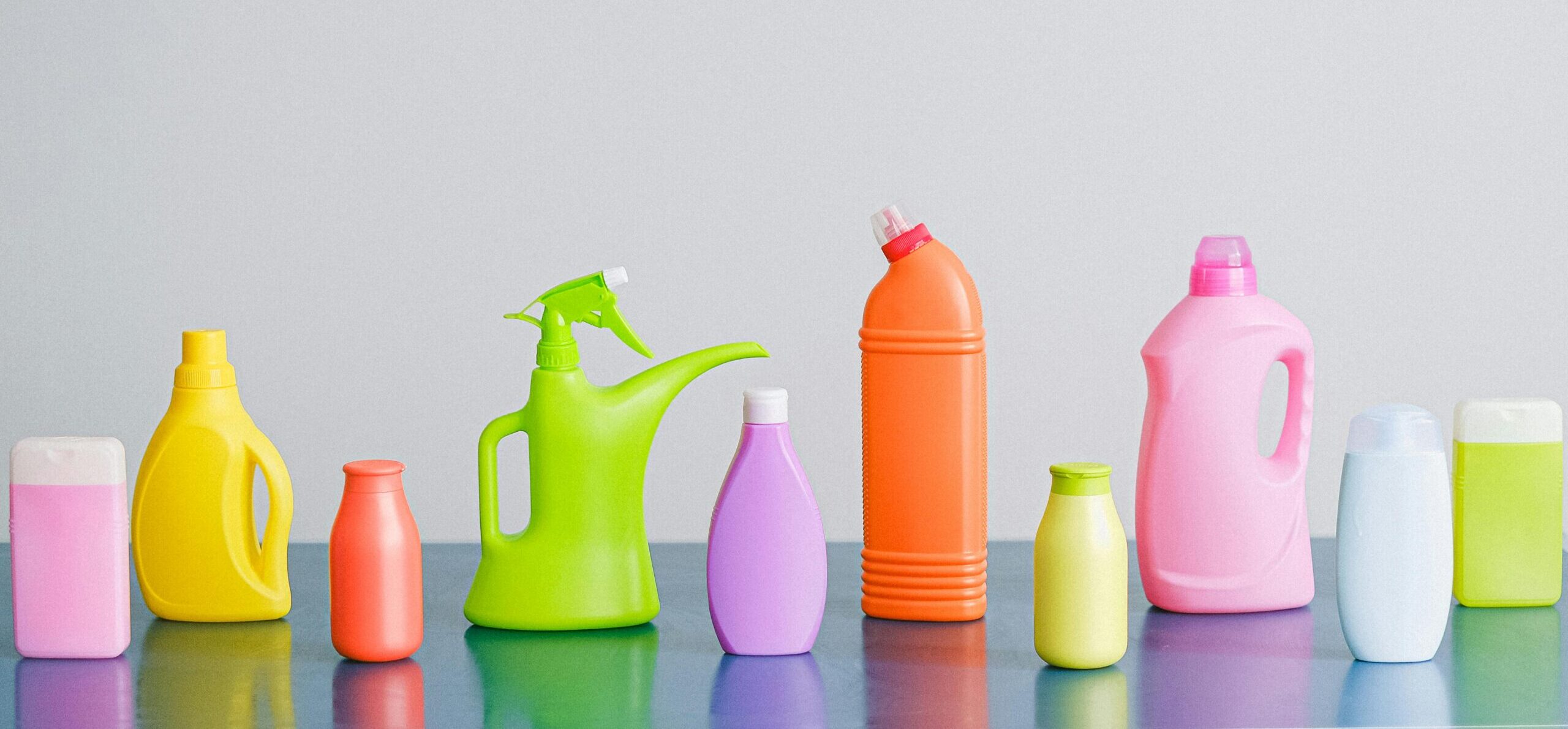 A vibrant assortment of cleaning product containers arranged on a reflective surface, perfect for household sanitation themes.
